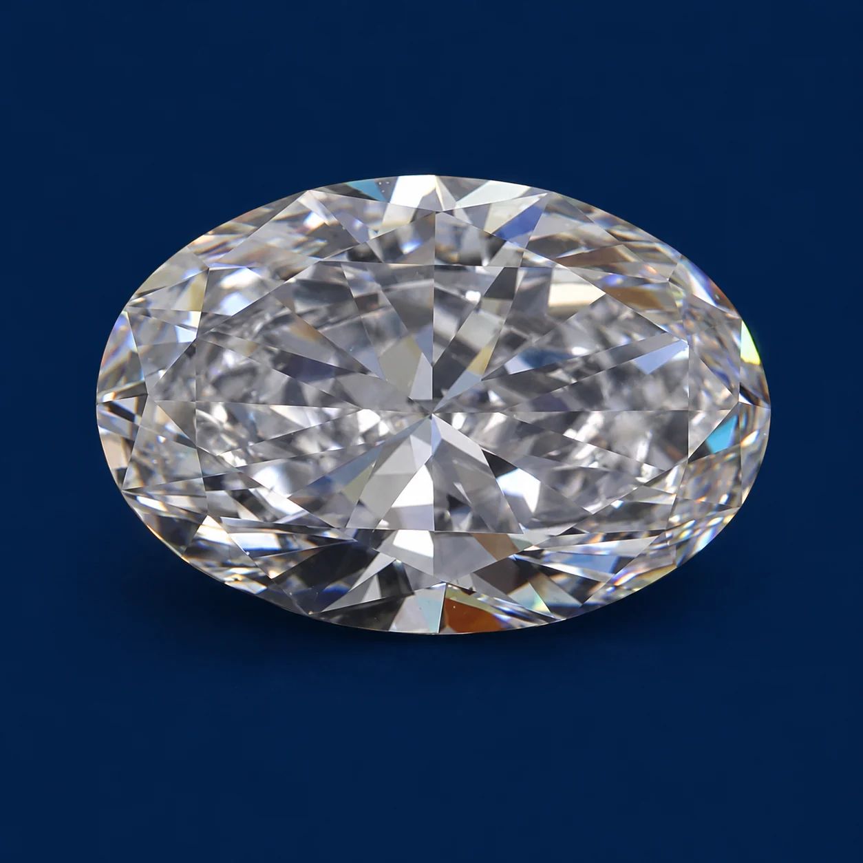 Oval loose diamond photographed face-up on a navy background