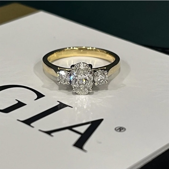 Three stone diamond engagement ring with an 18ct yellow gold shank and platinum setting.