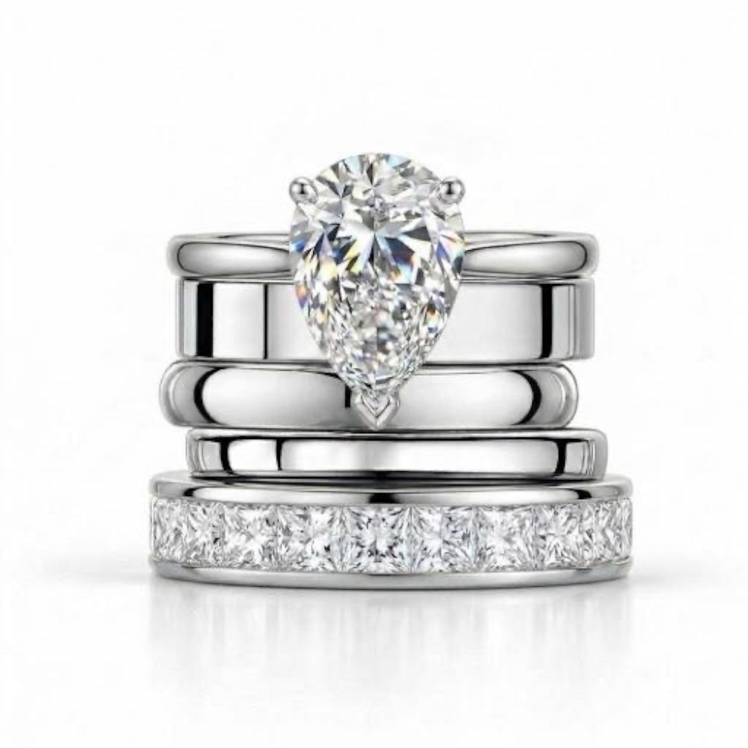 A pear shaped diamond engagement ring arranged with polished platinum bands and a diamond set wedding ring