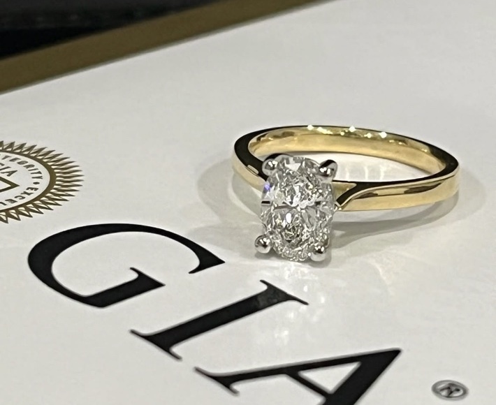 GIA-graded mined oval cut diamond engagement ring with platinum head and 18ct yellow-gold shank