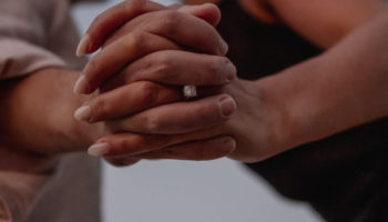 Sophie wearing her engagement ring while holding hands with Jordan by the sea