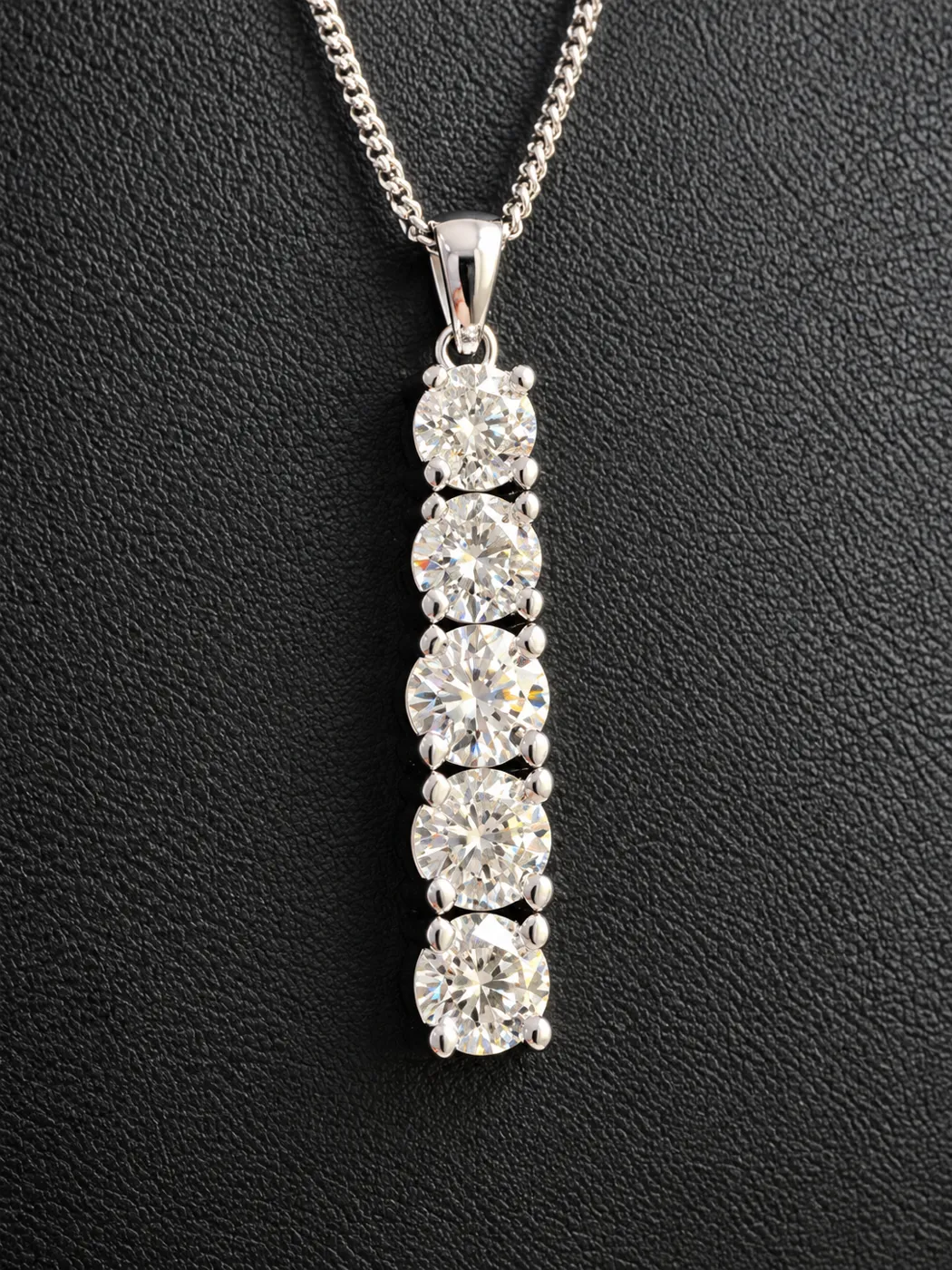 Five round brilliant diamonds from the customer's jewellery reset into a platinum drop pendant.