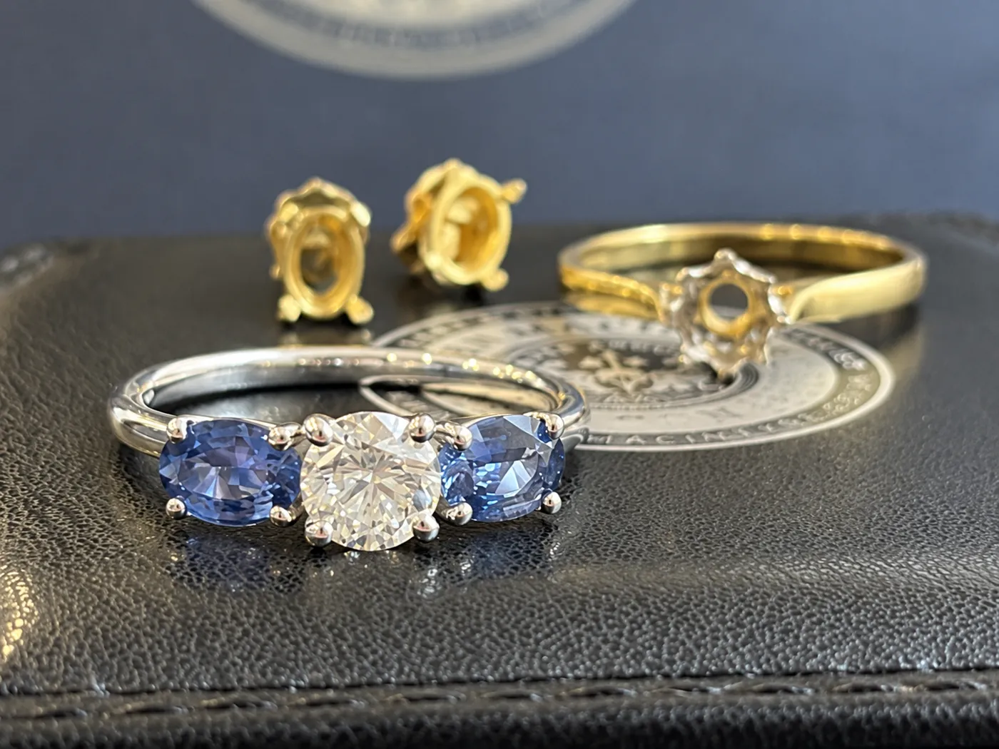 Platinum ring featuring the customer's diamond and two sapphires, shown from the front.