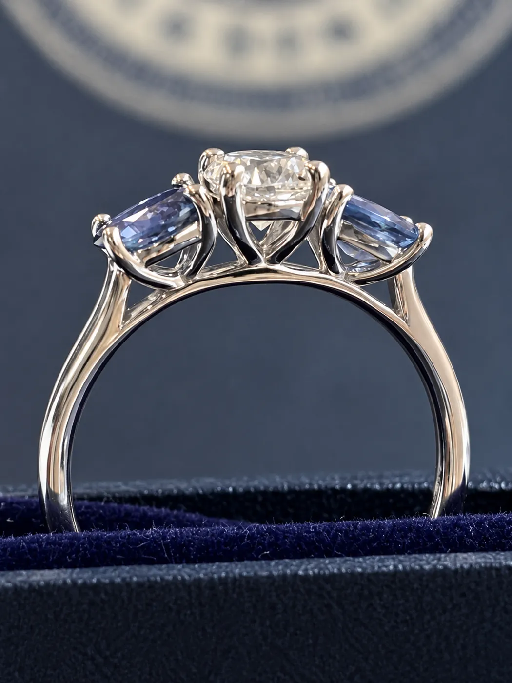 Side profile of the platinum three stone ring with two sapphires and a diamond.